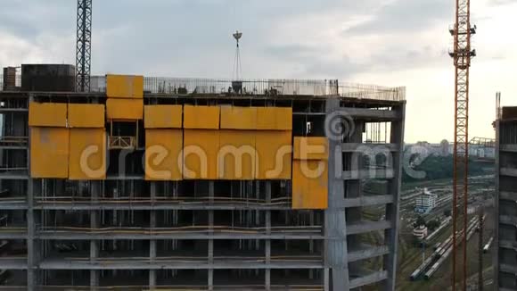 建筑工人从正在建造的摩天大楼屋顶上的起重机上取出水泥伸出电枢和黄色视频的预览图