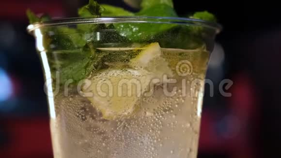 酒保把苏打水薄荷和柠檬混合在塑料杯里准备冷饮的过程视频的预览图