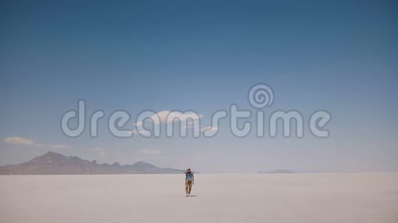 镜头跟随疲惫疲惫的年轻人独自走在危险的史诗般炎热的阳光盐湖在犹他州美国视频的预览图