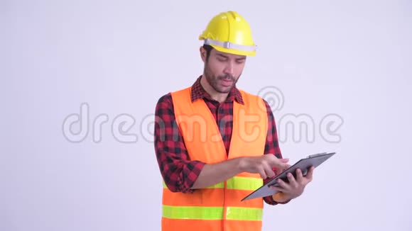 快乐留胡子的波斯人建筑工人一边读着剪贴板一边说话视频的预览图