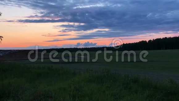 美丽的日落和乡村在金色的晚霞中把黄色的田野视频的预览图