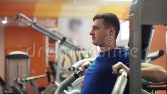 男性训练胸部肌肉使用运动机进行身体质量推推重量视频的预览图
