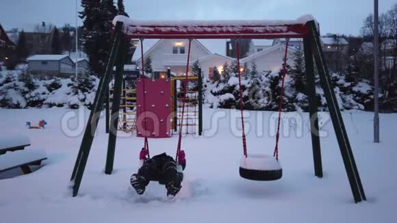 穿着摇摆轮胎的女孩被一场大雪覆盖视频的预览图