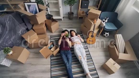 搬迁期间年轻人和女友躺在地板上收拾行李视频的预览图