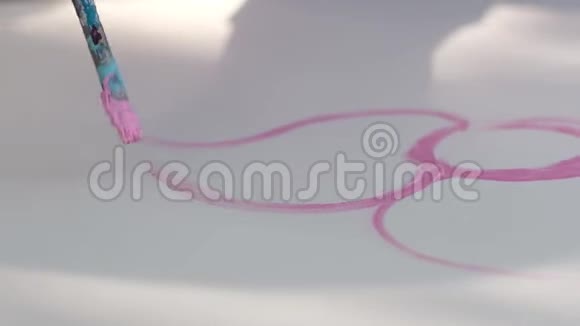 女艺术家用画笔在调色板上用粉红色颜料作画视频的预览图