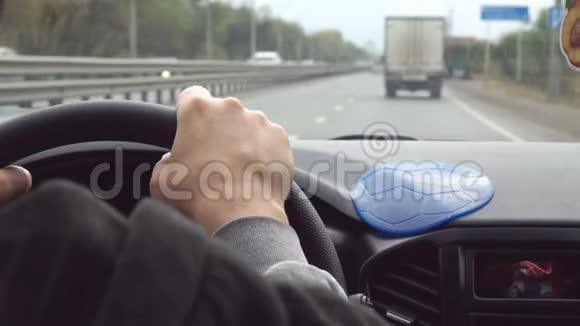 驾驶高速公路的汽车方向盘上的人的手视频的预览图