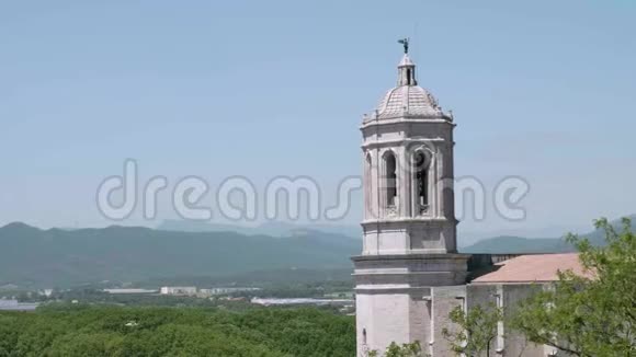 杰罗纳大教堂的白色钟楼鸟儿在天空中飞翔背景上的山在薄雾中视频的预览图