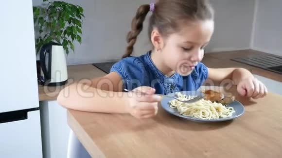 漂亮的小女孩在厨房里吃她的斯帕盖蒂意大利面晚餐视频的预览图