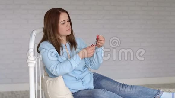一位糖尿病妇女坐在家里的床上用胰岛素注射器拨胰岛素视频的预览图