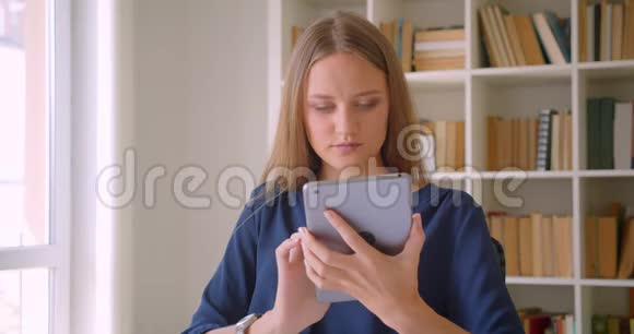 年轻有魅力的白种人女商人用平板电脑和绿色屏幕拍摄的特写照片视频的预览图