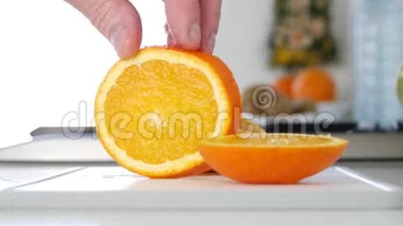 在厨房里闭上男人的手呈现新鲜甜橙水果片视频的预览图