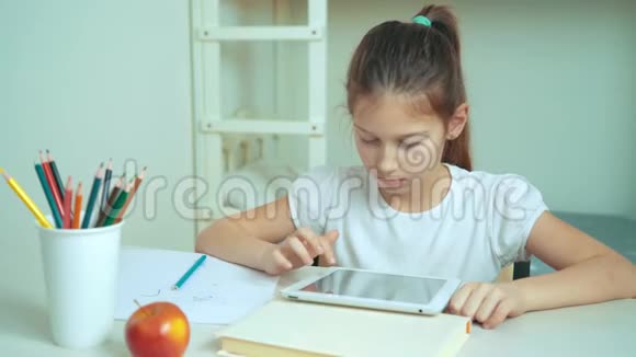 一个红头发的小女孩坐在桌上玩游戏视频的预览图