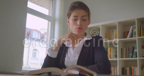年轻漂亮的白种人女学生在大学图书馆做笔记的特写镜头视频的预览图