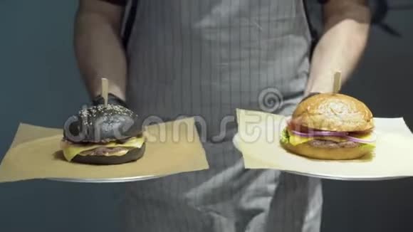 厨师或服务员的手在盘子里端着两个多汁的汉堡视频的预览图