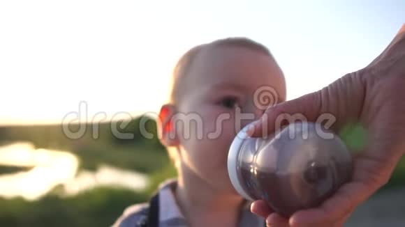 宝宝喝的是妈妈在日落时慢动作的奶瓶视频的预览图