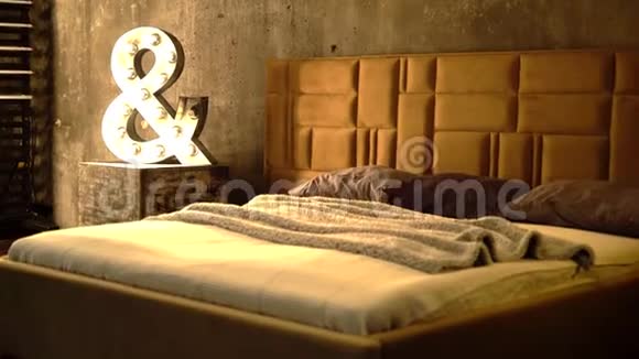舒适的床与被子皮革床头板米色和棕色和糊状枕头视频的预览图