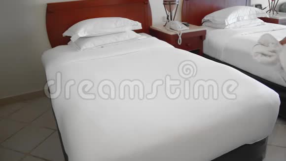 未被认出来的成年老太太把毛巾放在床上的白色长袍旁边打扫公寓的概念视频的预览图