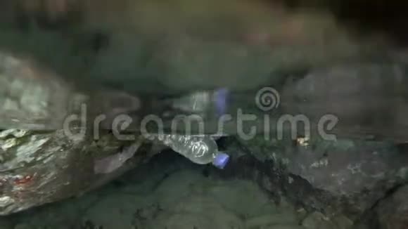 塑料污染水下分裂水平一个塑料瓶漂浮在洞穴里的水面上水下射击视频的预览图