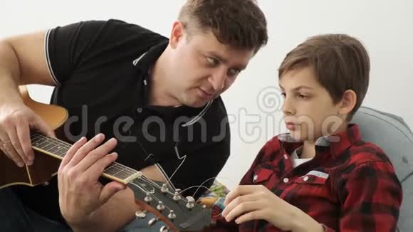 儿子说他是在父亲教他弹吉他近距离观看慢动作的时候得到的视频的预览图