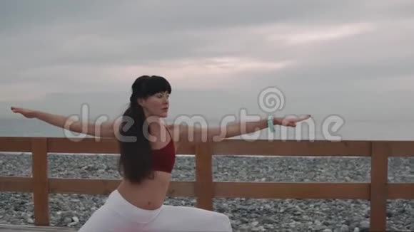 女人正在改变瑜伽体式在户外海边的位置视频的预览图