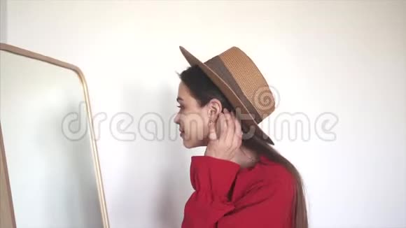 年轻快乐的女人试着在镜子前穿新衣服视频的预览图