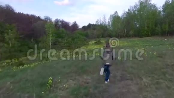 十几岁的男孩跑过森林里的草坪这个男孩心情很好视频的预览图