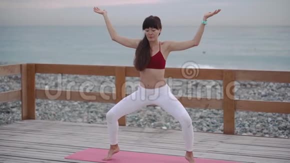 女人正在做瑜伽保持平衡完成锻炼视频的预览图