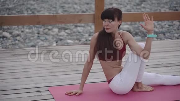 女运动员在瑜伽训练中伸展背部和腿部的肌肉和肌腱视频的预览图