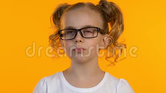 戴眼镜的漂亮博学的女孩有想法特写孤立的黄色背景视频的预览图