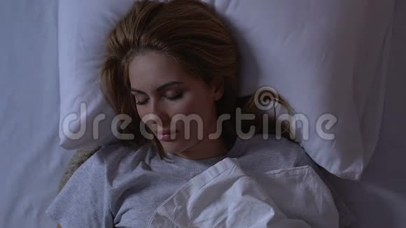 美丽的女士晚上躺在床上舒适的床垫上舒适的健康睡眠视频的预览图