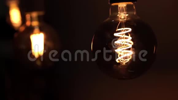 灯在黑暗中亮起黑色背景上的钨灯灯泡光明和黑暗的概念观念视频的预览图