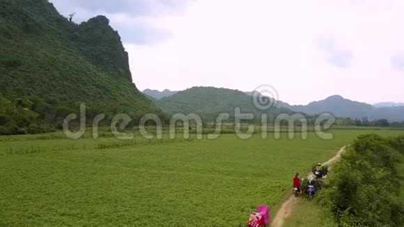 一对夫妇骑摩托车穿越无边的绿野原野视频的预览图