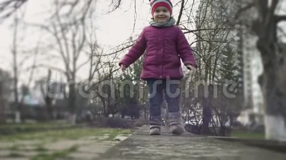 小女孩走在城市公园的栏杆边环顾四周对着镜头微笑幼稚的表情儿童教视频的预览图