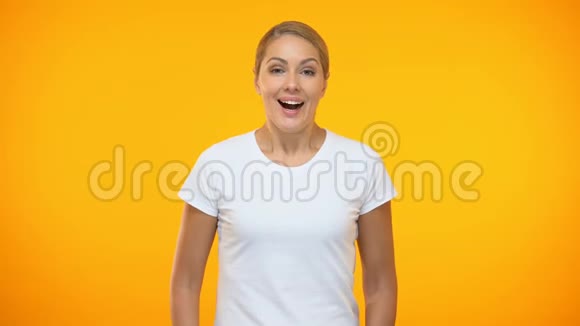 橙色背景下的年轻女子惊喜好消息惊喜幸福视频的预览图