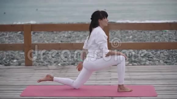 女瑜伽教练在海岸做运动视频的预览图