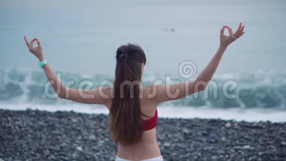 女士在练习冥想在海浪中眺望大海视频的预览图