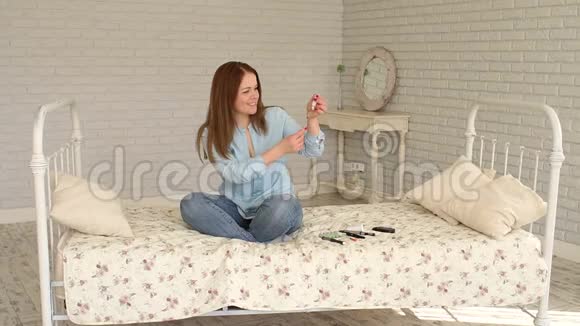 一位糖尿病妇女坐在家里的床上用胰岛素注射器拨胰岛素视频的预览图