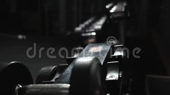 年轻女孩穿着运动服戴着健身手镯在长凳上放两个哑铃5公斤练习的结束视频的预览图