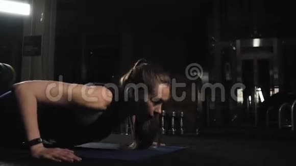 苗条的健身女孩在健身房锻炼从地板上执行推杆晚间训练体育生活方式视频的预览图