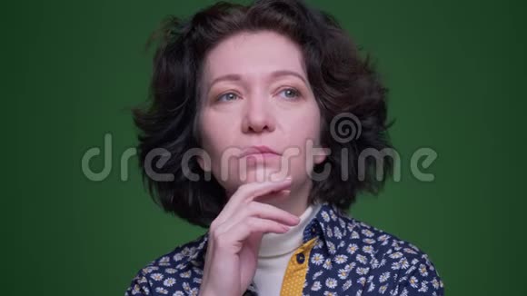 老白种人深色头发的女性的特写镜头在镜头背景下思考和困惑视频的预览图