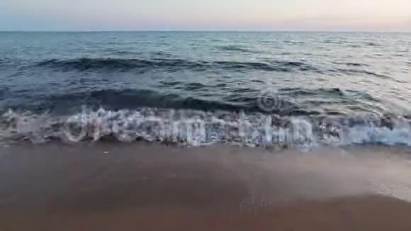 日落时分海浪拍打在基法洛尼亚沙滩上地平线上闪烁着温暖的光芒视频的预览图