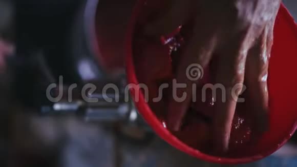 特写镜头一位老年妇女的手把切好的番茄推入榨汁机视频的预览图