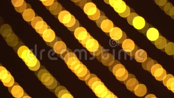 一排模糊不清的新年花环温暖的金色灯光衬托出美丽的圣诞节背景4K超高清视频的预览图