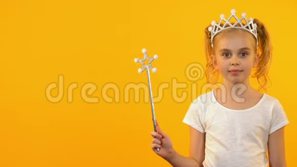美丽的公主女孩挥舞着魔杖对着镜头微笑快乐的童年视频的预览图