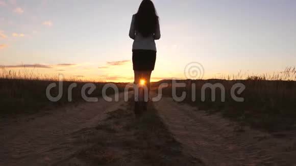一个女商人走在乡间的路上手里拿着一块平板电脑阳光洒在女人的腿性感性感性感视频的预览图