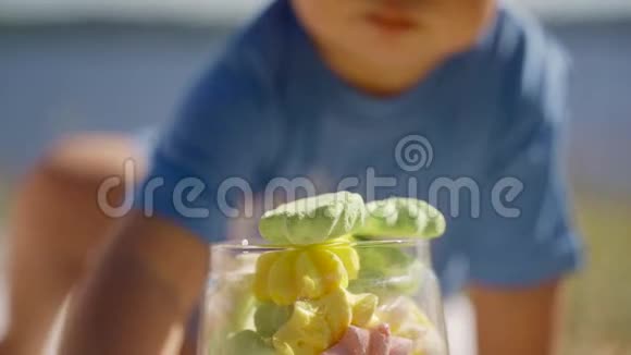 小男孩把棉花糖放在一个玻璃碗里家庭户外娱乐视频的预览图