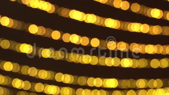 一排模糊不清的新年花环温暖的金色灯光衬托出美丽的圣诞节背景4K超高清视频的预览图