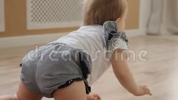 幸福婴儿的正面景色正在地板上爬行并试图直接向父母缓慢移动视频的预览图