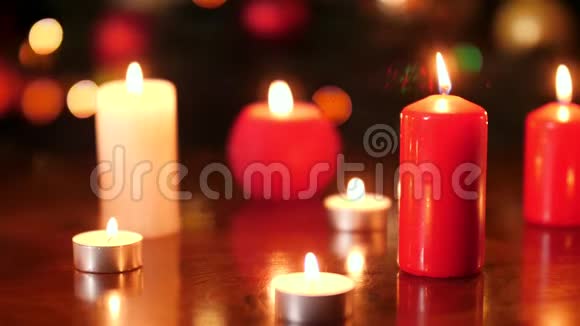 红色和白色燃烧蜡烛在夜间发光的彩色灯光下的4k视频完美的背景或背景视频的预览图