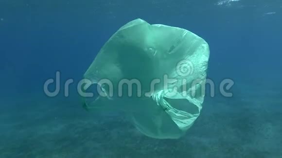慢的动作一个废弃的老绿色塑料袋慢慢地飘在蓝水的表面下水下塑料视频的预览图